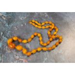 A 70cm string of oval butterscotch amber beads, gross weight 33.1g