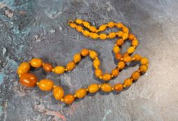 A 70cm string of oval butterscotch amber beads, gross weight 33.1g