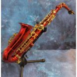 A Carmichael saxaphone, in red and gilt, cased; spare reeds; Seiko Chromatic Auto-Tuner;