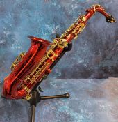 A Carmichael saxaphone, in red and gilt, cased; spare reeds; Seiko Chromatic Auto-Tuner;