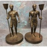 A pair of bronze figural candlesticks, cast as Nubians, holding staffs, 19th century