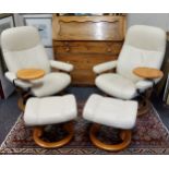 A pair of cream leather Ekornes Stressless armchairs with matching footstools.