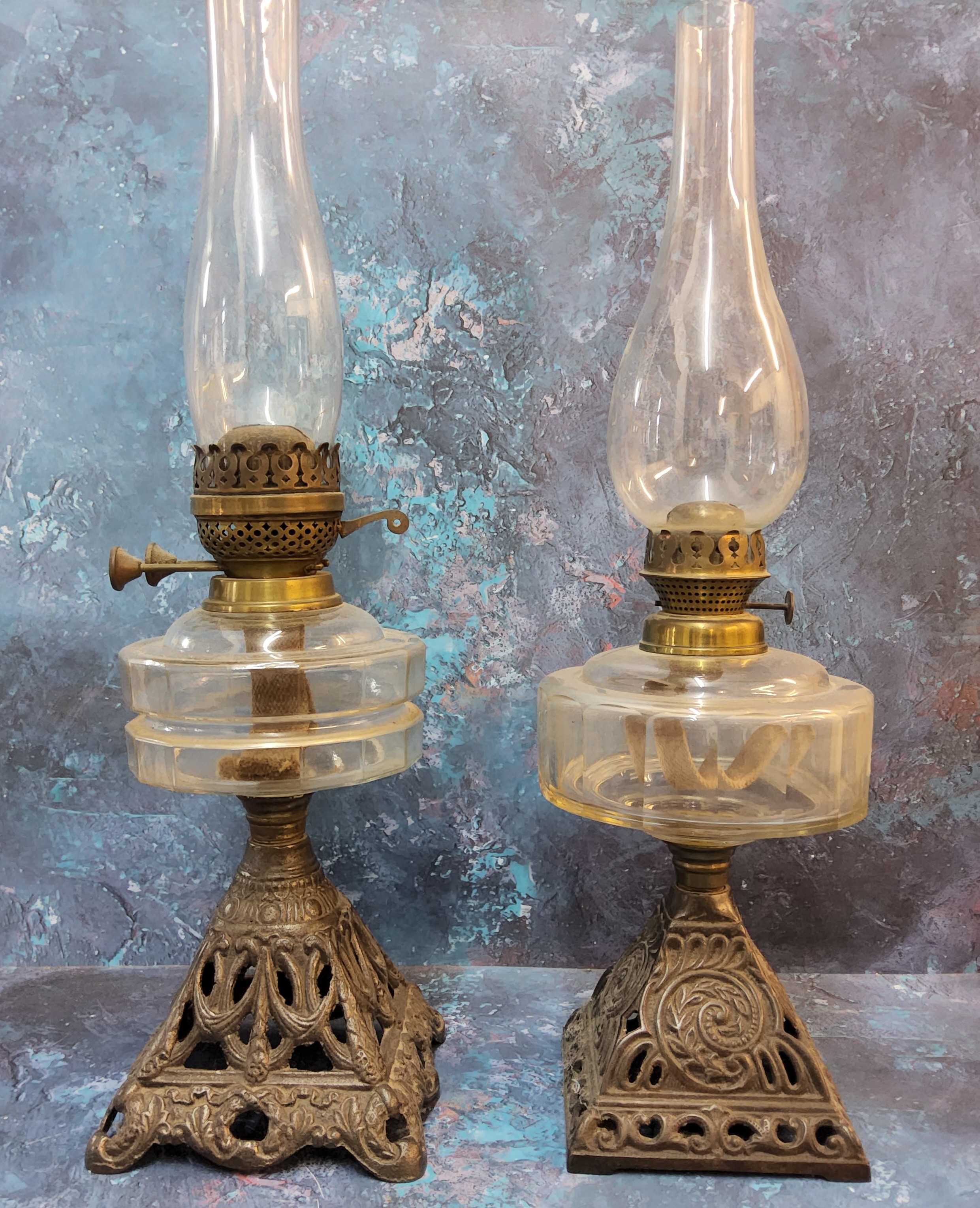 A Victorian cast iron oil lamp, clear glass resevoir, pierced cast iron base, 51cm high, c.1890;