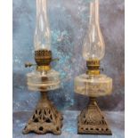 A Victorian cast iron oil lamp, clear glass resevoir, pierced cast iron base, 51cm high, c.1890;