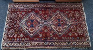 A Turkish woollen rug, with central gull, on a red ground, 98cm x 166cm