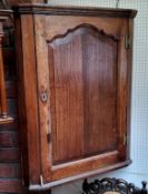 A George III oak splay front corner cabinet, shaped fielded panelled door, 98cm high, 79cm wide, c.