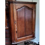 A George III oak splay front corner cabinet, shaped fielded panelled door, 98cm high, 79cm wide, c.