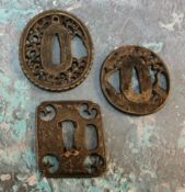 A Japanese iron tsuba, oval, pierced with blossoming prunus, 4.5cm wide;  others (3)