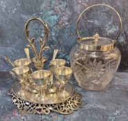 A 19th century plated ware egg stand, six cups and spoons, posted loop handle, pierced scroll