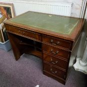 A reproduction mahogany kneehole desk, tooled green leather inlaid writing surface, fall front