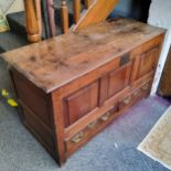 An 18th century oak blanket box, hinged cover, three panelled front, above two drawers, 70cm high,