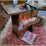 A mid 20th century oak sewing side table, the frieze carved with a flower and foliage, 58cm high,