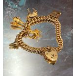 A 9ct gold graduated charm bracelet, four charms, padlock clasp 29.9g