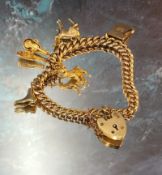 A 9ct gold graduated charm bracelet, four charms, padlock clasp 29.9g