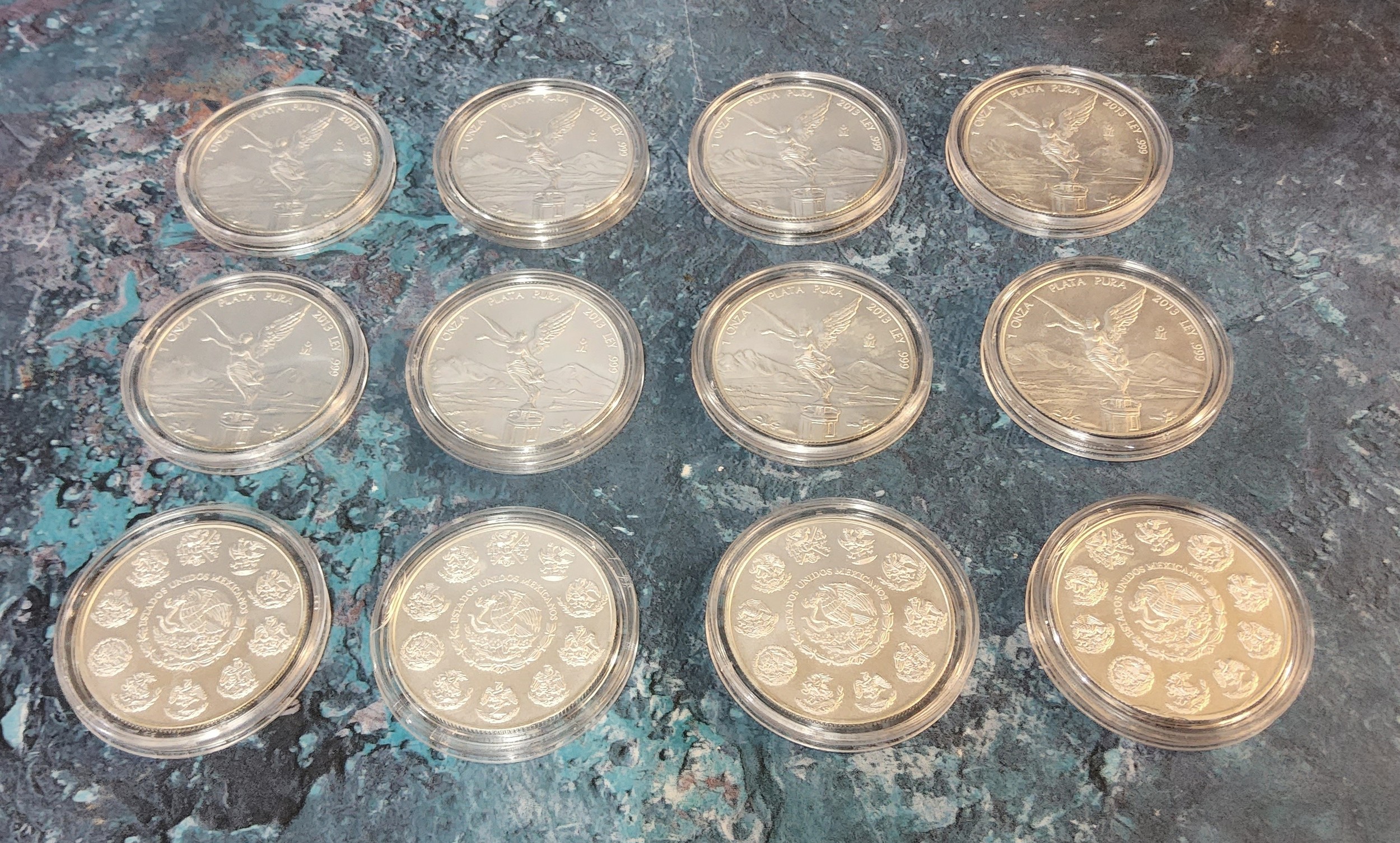 Twelve Mexican Libertad 2013 1oz Fine Silver Coin, all contained in plastic protective cases
