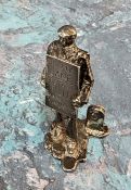 A novelty silver place card/menu holder,   cast as a man with a sandwich board, advertising shows on