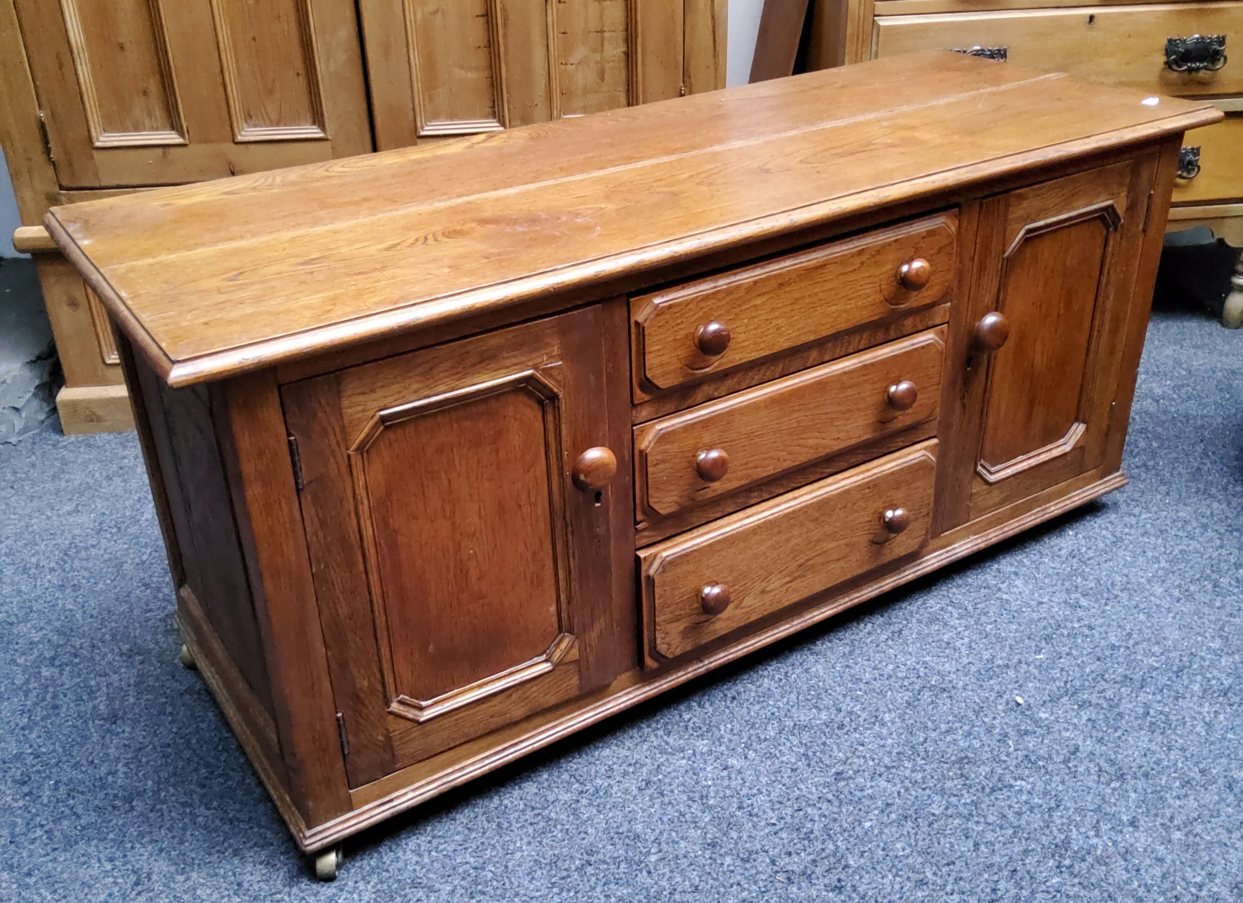 A modern English oak side unit, with three long graduated drawers flanked by a pair of fielded