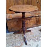 A Victorian English oak octagonal wine table with turned column support raised on tripod of cabriole