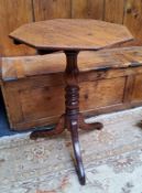 A Victorian English oak octagonal wine table with turned column support raised on tripod of cabriole