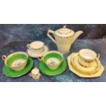 A pair of Aynsely teacup and saucers, the centres with colourful flowers, banded in apple green,