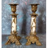A pair of 19th century French bronze and opaque glass candlesticks, foliate cast sconces, white