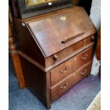 An 18th century oak bureau, the fall front enclosing well and pigeon holes, above two drawers,