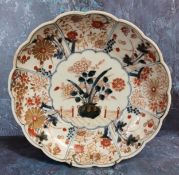 A Japanese Imari shaped circular plate, decorated with jardinere and chrysanthemums, the sides