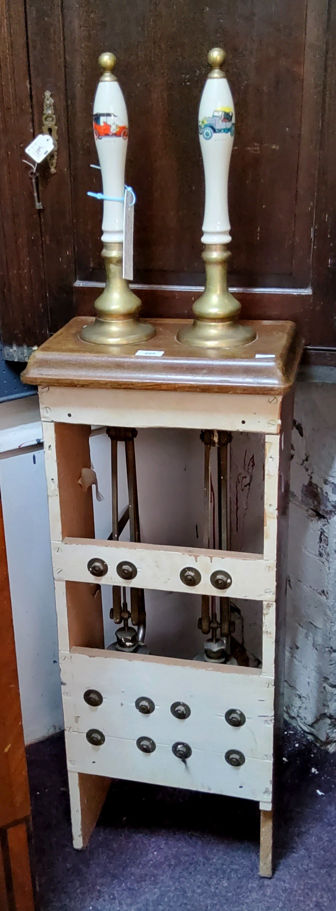 An 20th century beer pump, holding two ceramic pulls, complete with workings in a wooden housing,