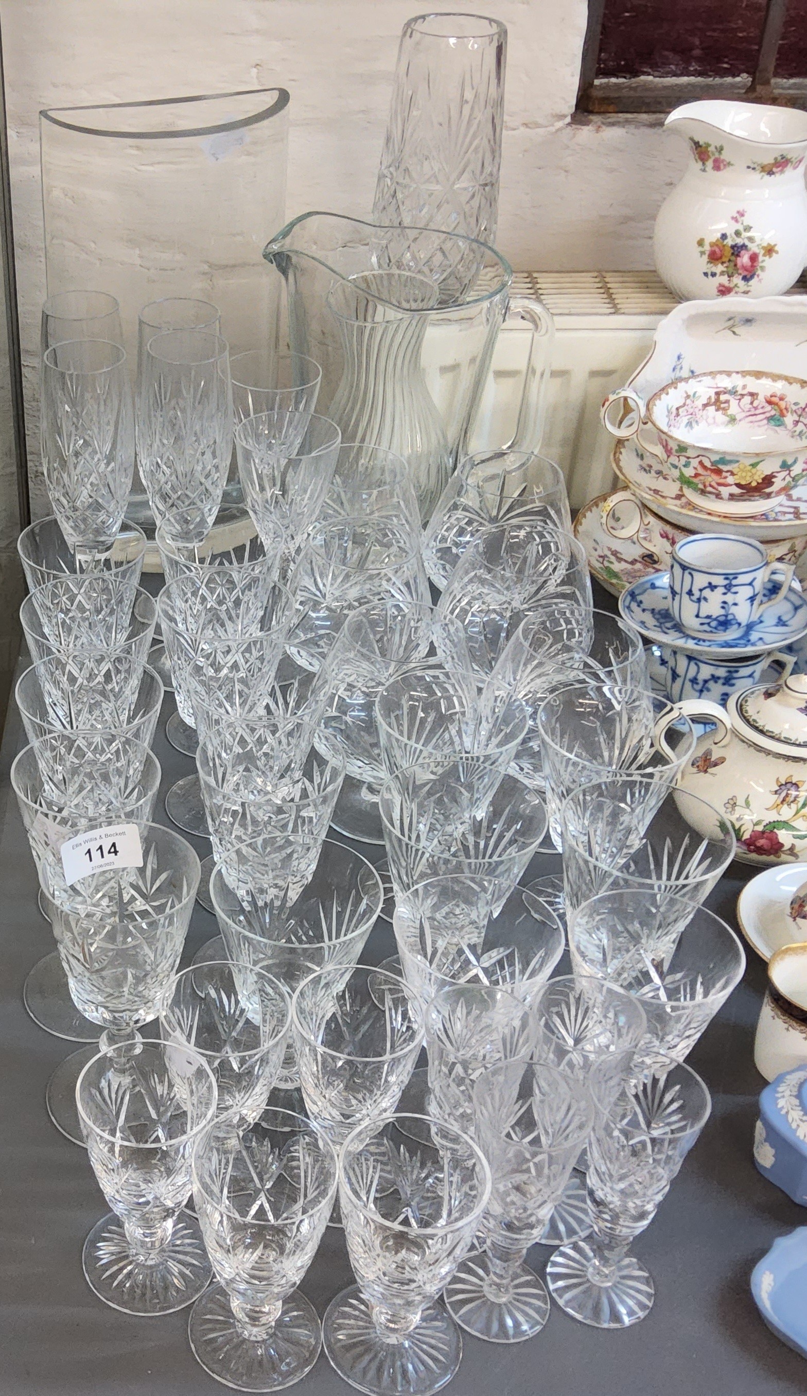 A part cut glass drinking suite, comprising four champagne flutes, six  brandy glasses, nine large