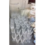 A part cut glass drinking suite, comprising four champagne flutes, six  brandy glasses, nine large