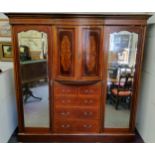 A good Edwardian Sheraton Revival satinwood inlaid triple wardrobe, of break-bow fronted form, the