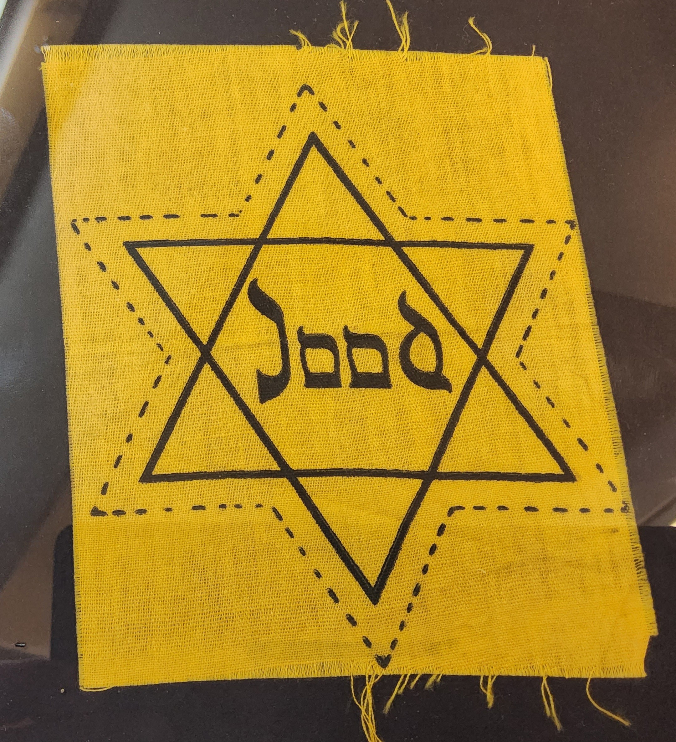 A WWII Dutch Jewish patch in the form of the Star of David with the word 'Jood' in the centre,