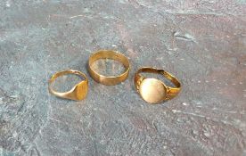 A 9ct gold band, size S; two 9ct gold signet rings, cut; 6.65g total