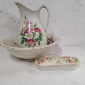 An English pottery wash jug, bowl and tooth brush box and cover, painted with flowers and foliage,