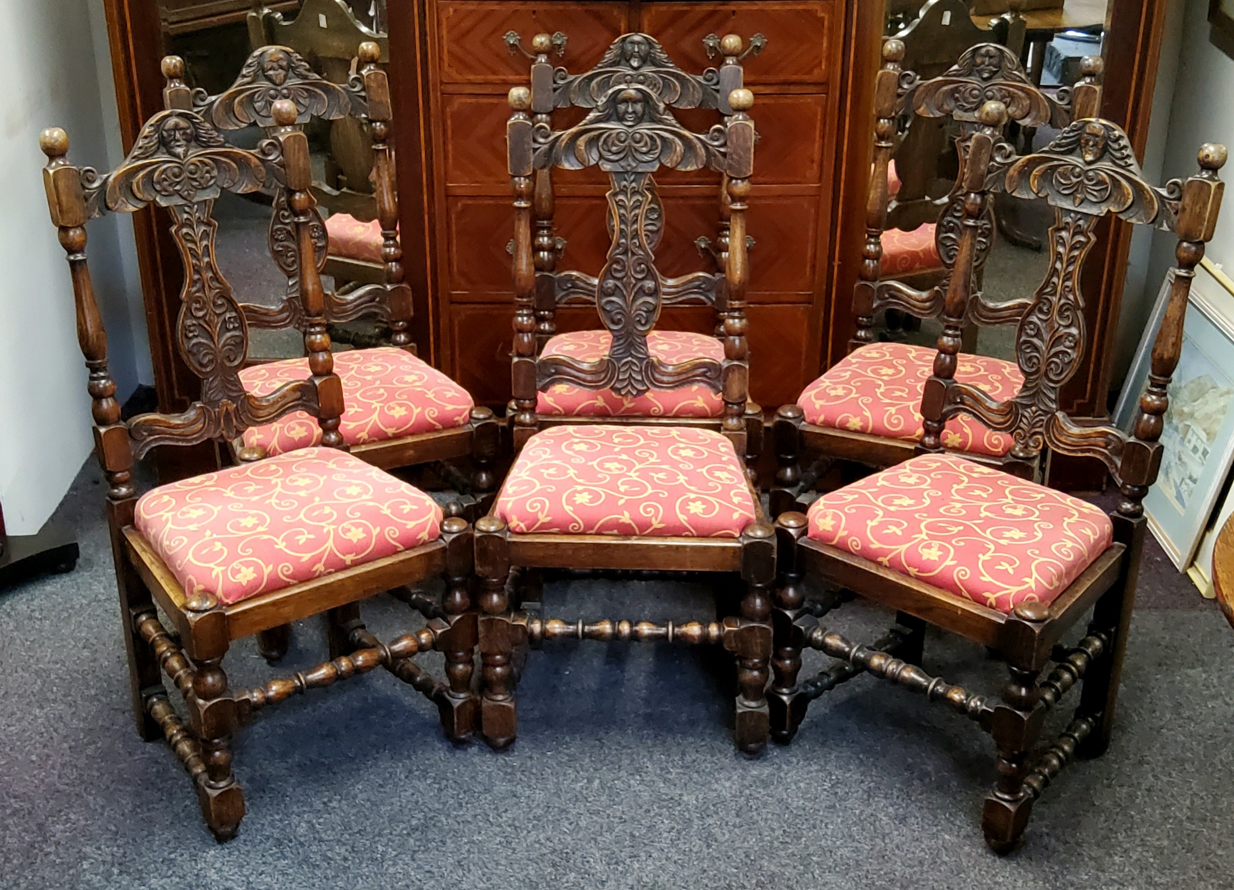 A set of six oak dining chairs, in Cromwellian style,  the cresting rail carved with masks and