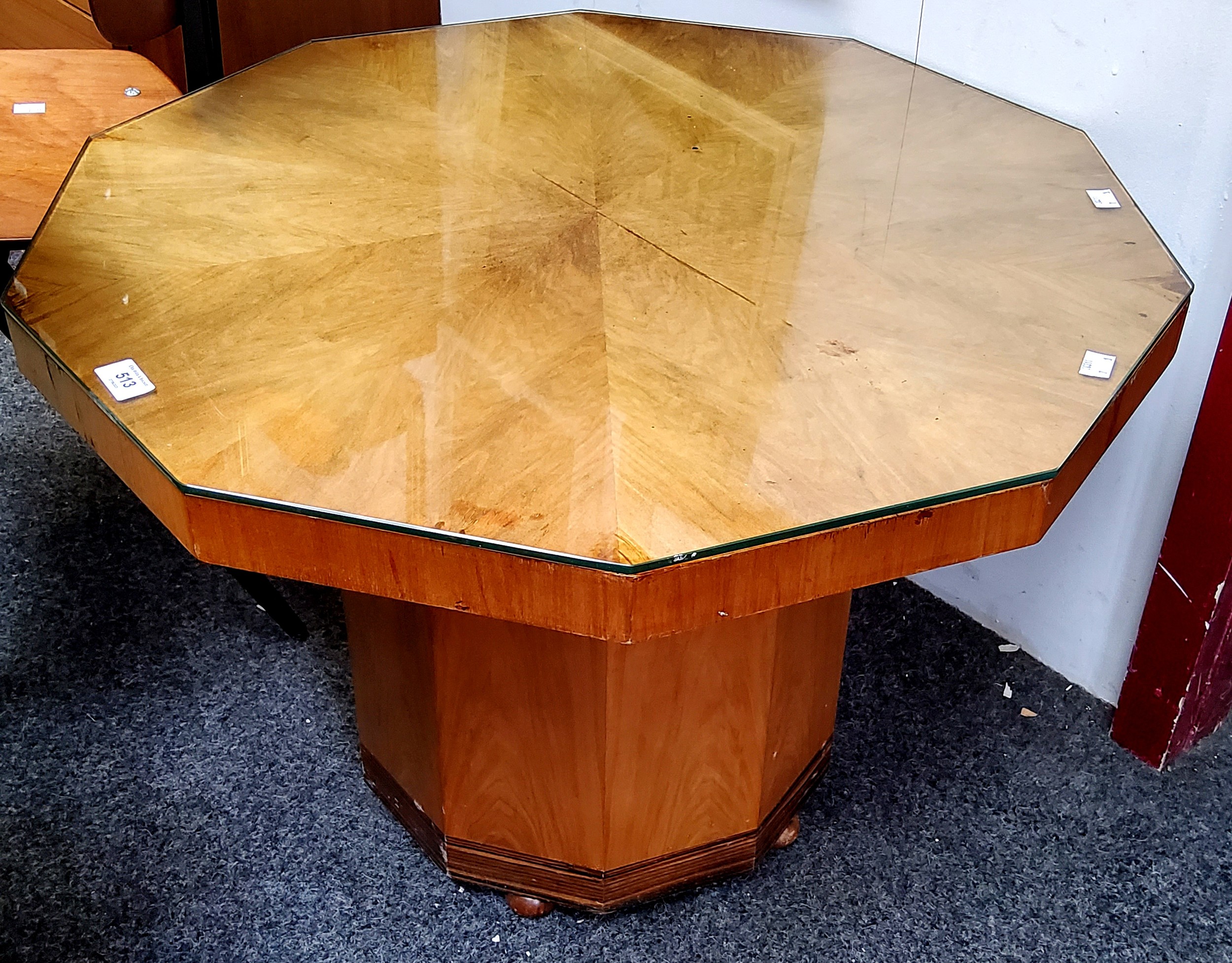 An Art Deco maple veneered decagon shaped occasional table, glass surface, 76cm wide, 52cm high, c.