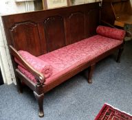 An 18th century oak settle, rectangular back with four  arched raised and fielded panels, shaped