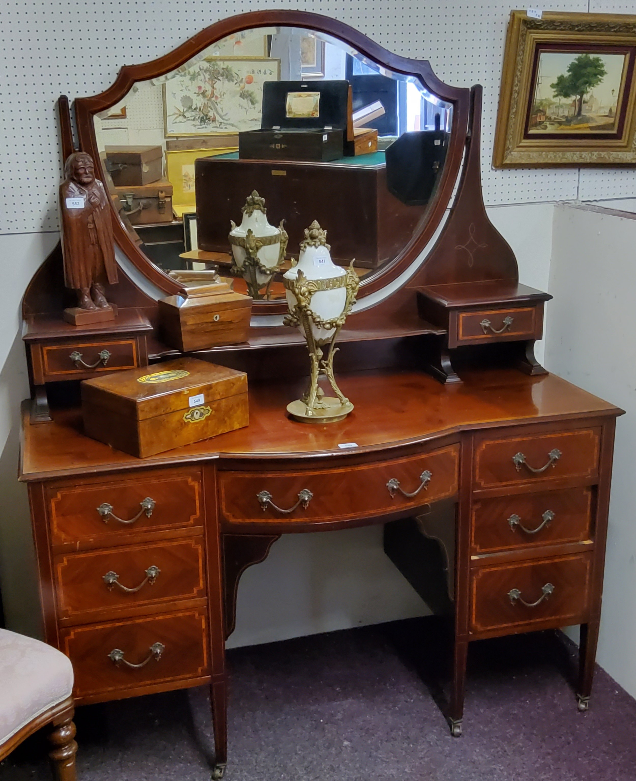 An Edwardian Sheraton Revival satinwood inlaid dressing table, shield shaped mirror, the bow