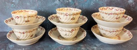 A set of six Newhall tea bowl and saucers, wrythen moulded, decorated in famille rose with