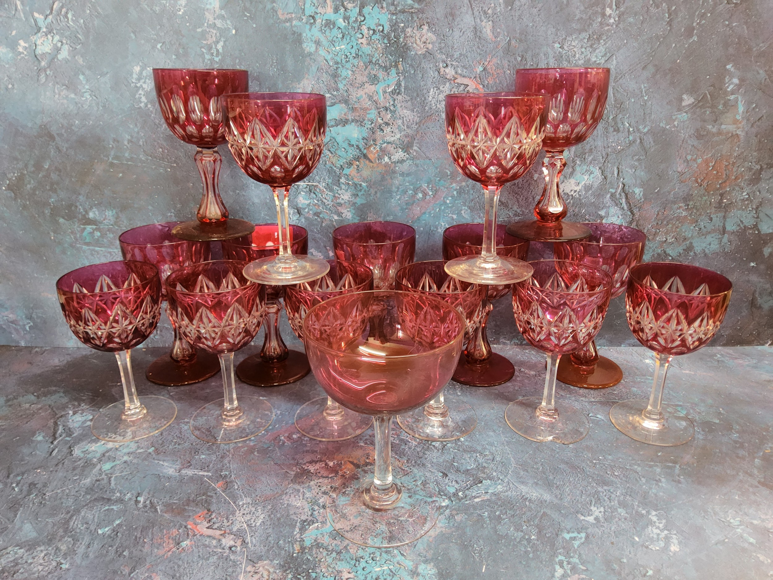 A set of seven ruby glass overlaid wine glasses, waisted columns, spreading circular bases, 12.
