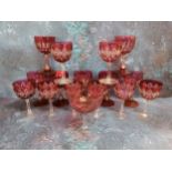A set of seven ruby glass overlaid wine glasses, waisted columns, spreading circular bases, 12.