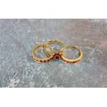 A 9ct gold half eternity ring set with ten round rubies, size O; another set with seven rubies, size