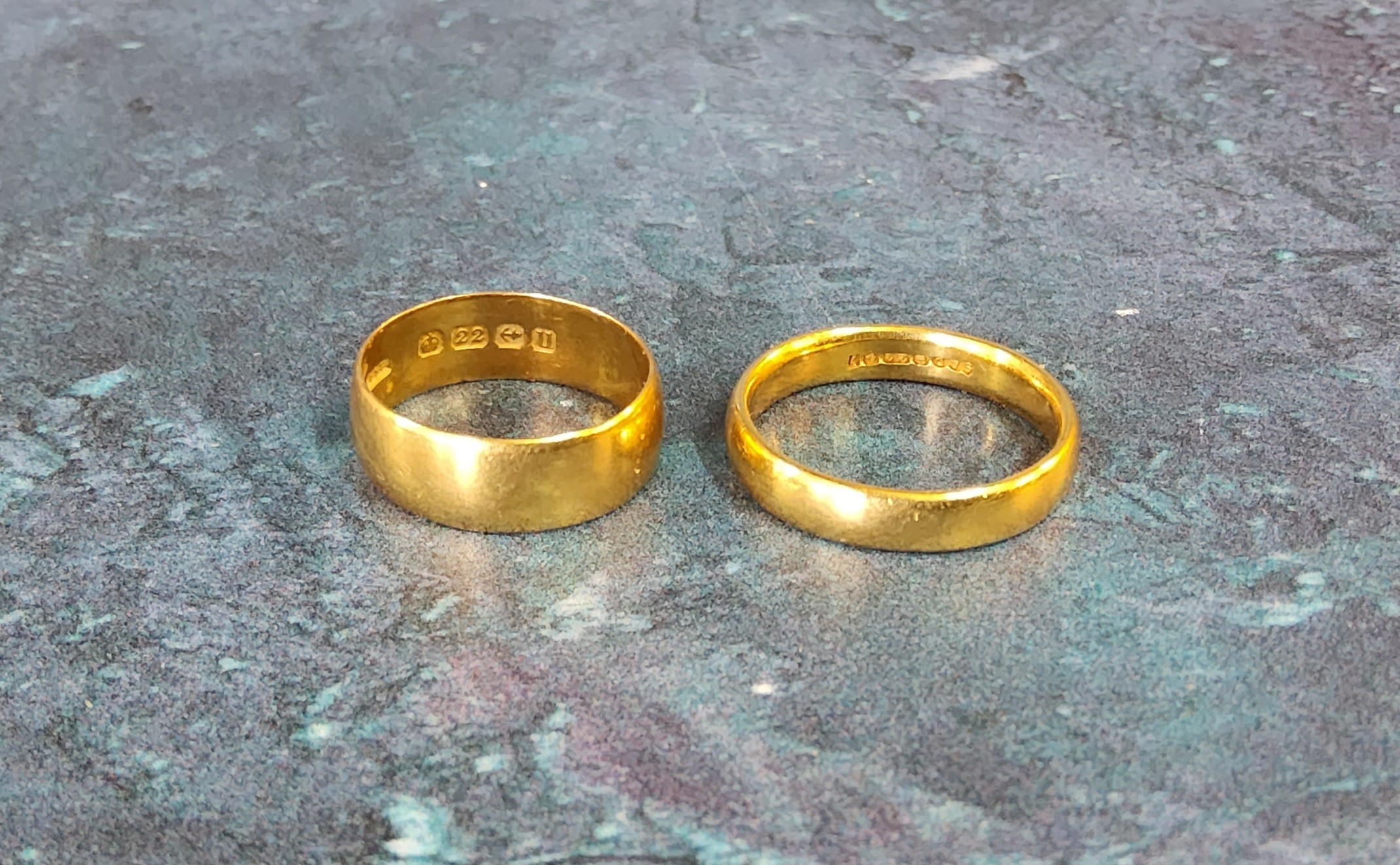 A 22ct gold half barrel band, size N; another size K 8.2g total (2)