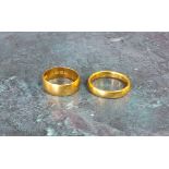 A 22ct gold half barrel band, size N; another size K 8.2g total (2)