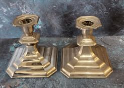 A pair of Continental silver coloured metal  candlesticks, canted sqare sconces, spreading bases,