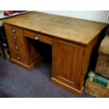 An early 20th century pitch pine pedestal desk, later top, with 1920's cup handles, holding one