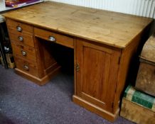 An early 20th century pitch pine pedestal desk, later top, with 1920's cup handles, holding one