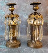 A pair of Regency bronze candle lustres, cast with stylised leaves, clear glass prismatic