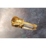 A 9ct gold novelty brooch in the form of a guitar approx. 5cms long 9.2g (VAT on Hammer price)