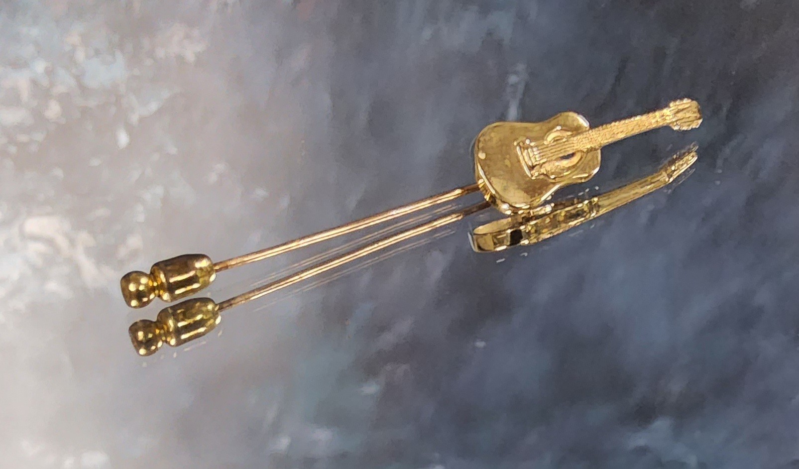 A 9ct gold stick pin, the finial as a guitar, JS, Sheffield 3.42g (VAT on Hammer price)